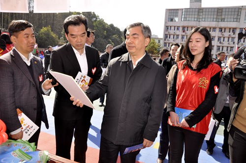 图为省常委、宣传部长梁伟年参观志愿助残资料