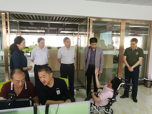 陈远祥（右二）、李邦和（中）在巴东县残疾人“追梦人”就业创业孵化基地了解残疾学员培训情况