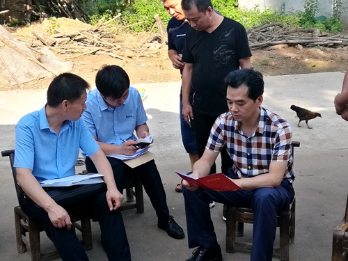 图为朱志斌查看扶贫手册 图为朱志斌查看扶贫手册